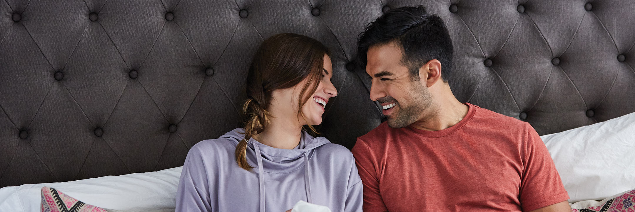 young couple laughing in bed